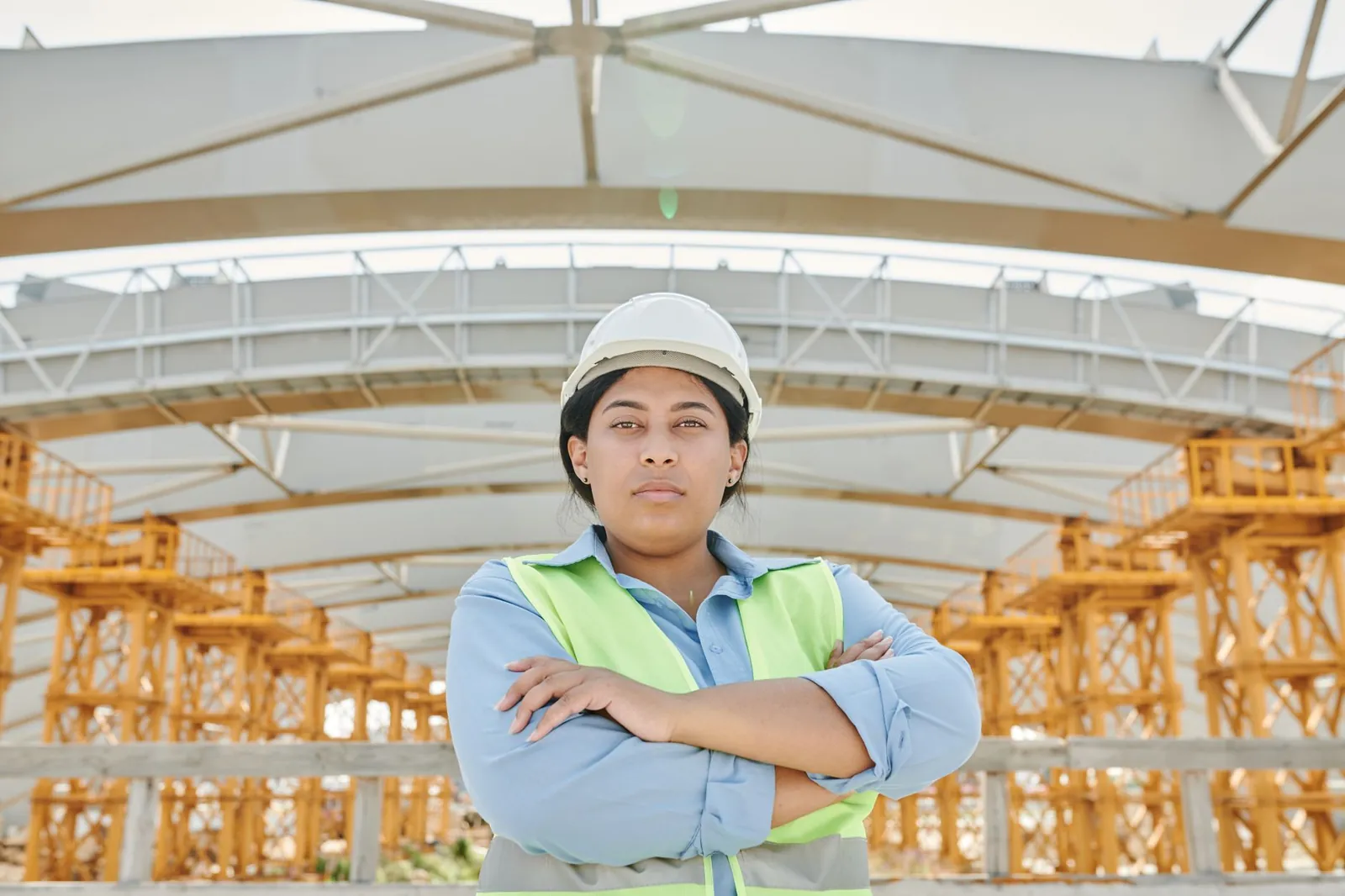 Ingeniera con casco y chaleco de seguridad en una nave industrial